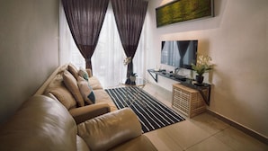 A modern living room with a leather sofa, a black and white striped rug, a small side table with a plant, and a large framed artwork on the wall. - Merton Residence Ipoh (Ipoh)