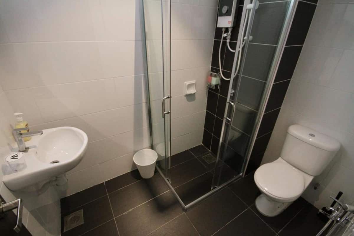 Un baño con lavabo, inodoro y cabina de ducha de cristal.