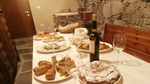 A dining table set with various dishes, wine glasses, and a bottle of wine. - Agritur La Gemma (Sant'Orsola Terme)