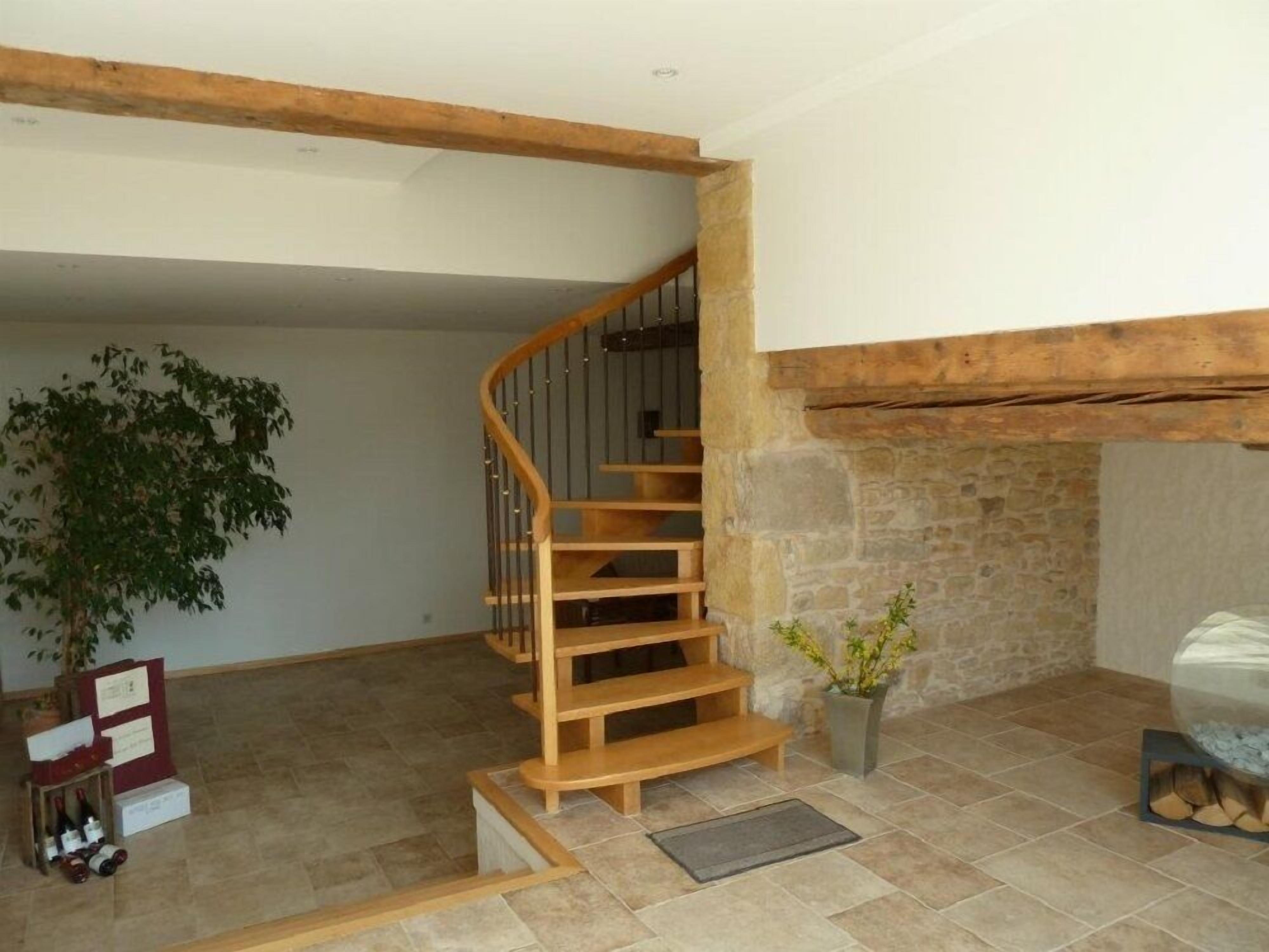 A wooden staircase with a stone wall and a potted plant.