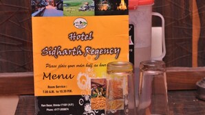 Cardápio do Hotel Sidharth Regency, com horários de serviço de quarto e informações de contato.