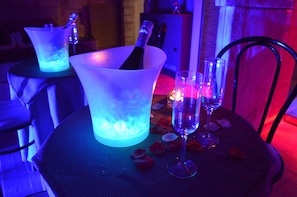 A table with a champagne bucket, a glass, and rose petals. - B&B Vesuvius (Naples)