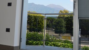 Une pièce dotée d’une grande porte-fenêtre coulissante donnant sur un balcon avec vue sur les montagnes.