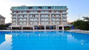A hotel with a large swimming pool, multiple floors, and balconies. - Pelikan Otel (Istanbul)