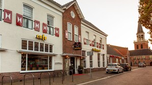 Une rue où se trouvent un café et un hôtel.