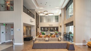 A spacious lobby with a central seating area, a staircase, and a kitchen in the background. - Holiday Inn Express Farroupilha by IHG (Farroupilha)
