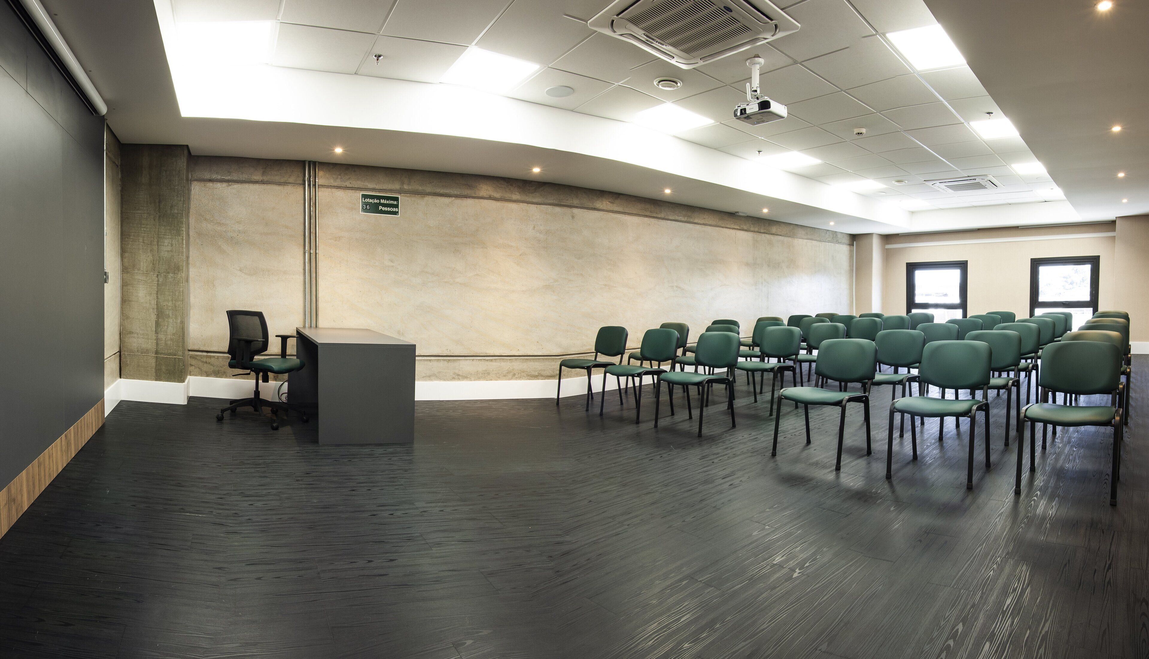 A conference room with a stage, a podium, and rows of chairs.