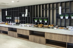 Enjoy a diverse spread of food and drink options at our buffet, featuring multiple serving stations and convenient storage.