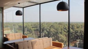 Un intérieur moderne avec un canapé et une table, de grandes fenêtres donnant sur une vue imprenable sur la forêt.