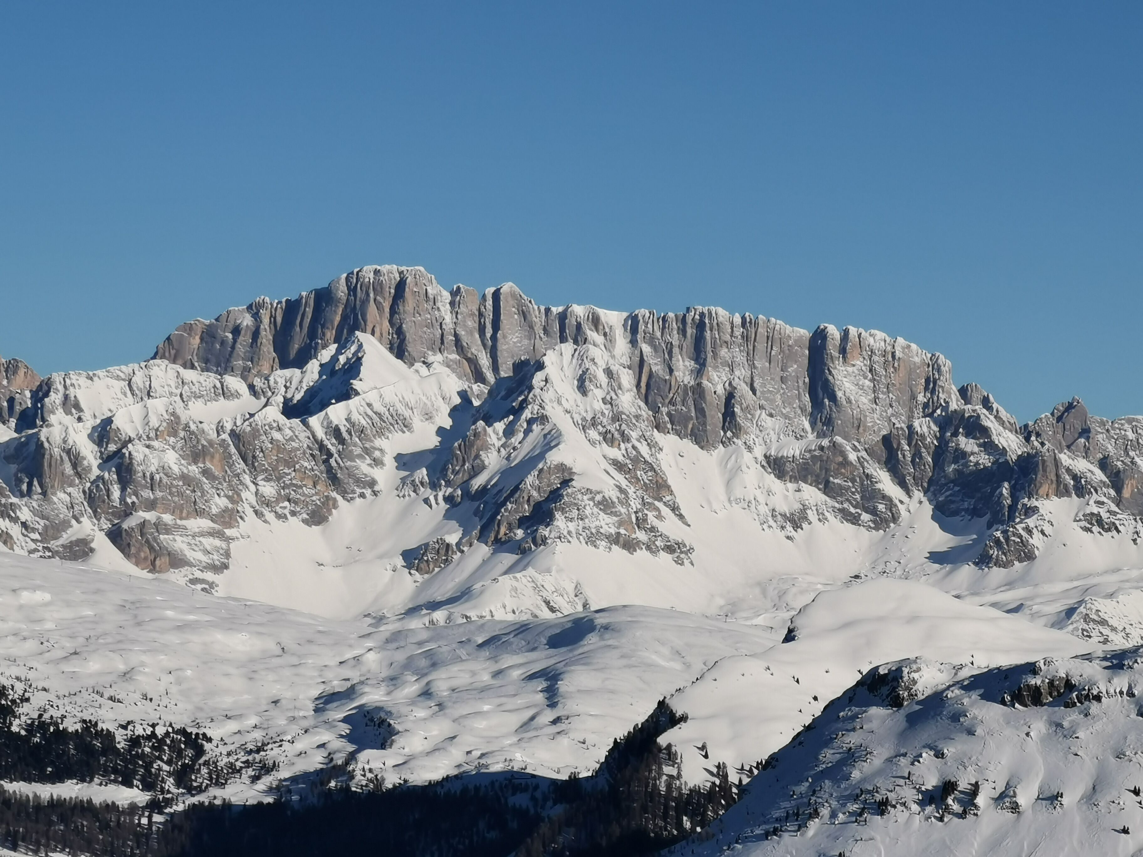 A snow-covered mountain with rugged peaks and a clear sky.
