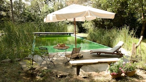 A poolside area with a table, chairs, a bench, and an umbrella. - Il Poggio B&B (Scandicci)
