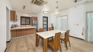 A modern kitchen with wooden cabinets, a central island, and pendant lighting.