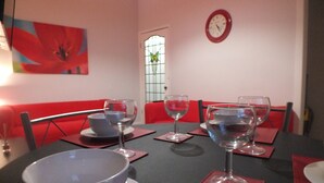 A dining table set with red placemats, clear wine glasses, and a white bowl. - Walthall Place (Crewe)