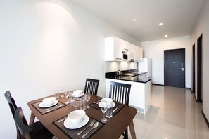 A modern kitchen with white cabinets, a black countertop, and a built-in microwave.