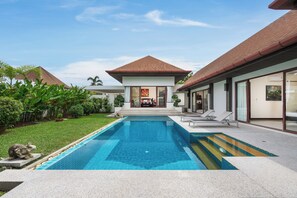 A modern house with a swimming pool, a dining area, and a well-maintained garden. - Villa Iorangi (Rawai)