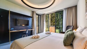 A modern hotel room with a large bed, a flat-screen TV, a desk, and a view of the outdoors. - Lyra Hotel Plitvice (Plitvicka Jezera)