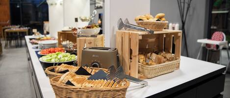 Una mesa de buffet con diversos alimentos y utensilios.