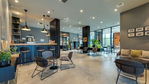 A modern interior with a bar area, seating, and large windows. - Lyra Hotel Plitvice (Plitvicka Jezera)