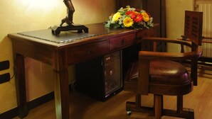A wooden desk with a lamp, a television mounted on the wall, a floral arrangement, and a wooden chair. - Muro Torto Cairoli (Foggia)