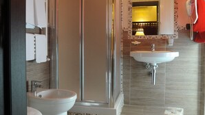 A modern bathroom with a glass-enclosed shower, a white sink, and a toilet. - Muro Torto Cairoli (Foggia)