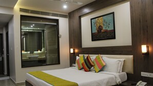 Una habitación de hotel con una cama grande, un teléfono junto a la cama y una mesita de noche.