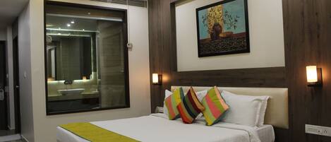 A hotel room with a large bed, a bedside telephone, and a nightstand.