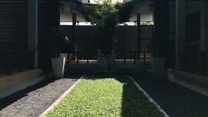 A courtyard with a central lawn, surrounded by buildings with traditional architecture. - The Nest Samui (Koh Samui)