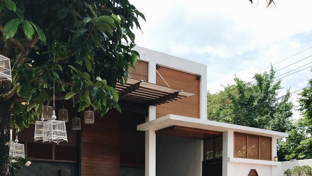 A modern outdoor pool area with a wooden deck, a small bar area, and a covered seating space. - The Nest Samui (Koh Samui)