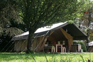 A tented accommodation with a table and chairs set up under a large tree. - Domaine St-Paul le Marseillais Tentes (Meze)