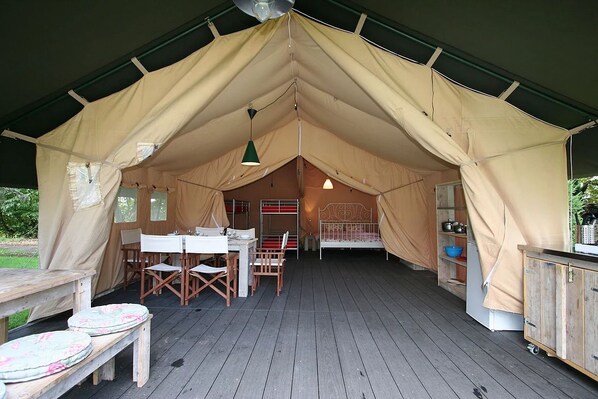 Una tenda amb zona de menjador, llit i petita cuina.