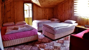 A wooden cabin with two beds, a red couch, and a patterned rug. - Yaren Otel (Çaykara)