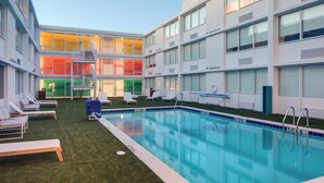 A modern hotel with a swimming pool, multiple balconies, and a rooftop area. - Hotel Indigo Memphis Downtown by IHG (Memphis)