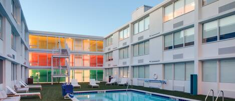 Una piscina al aire libre de temporada, sillones reclinables de piscina