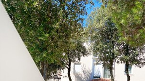 Una villa llamada "Villa Elizabeta" con un patio empedrado, rodeada de árboles y un edificio con tejado de tejas.