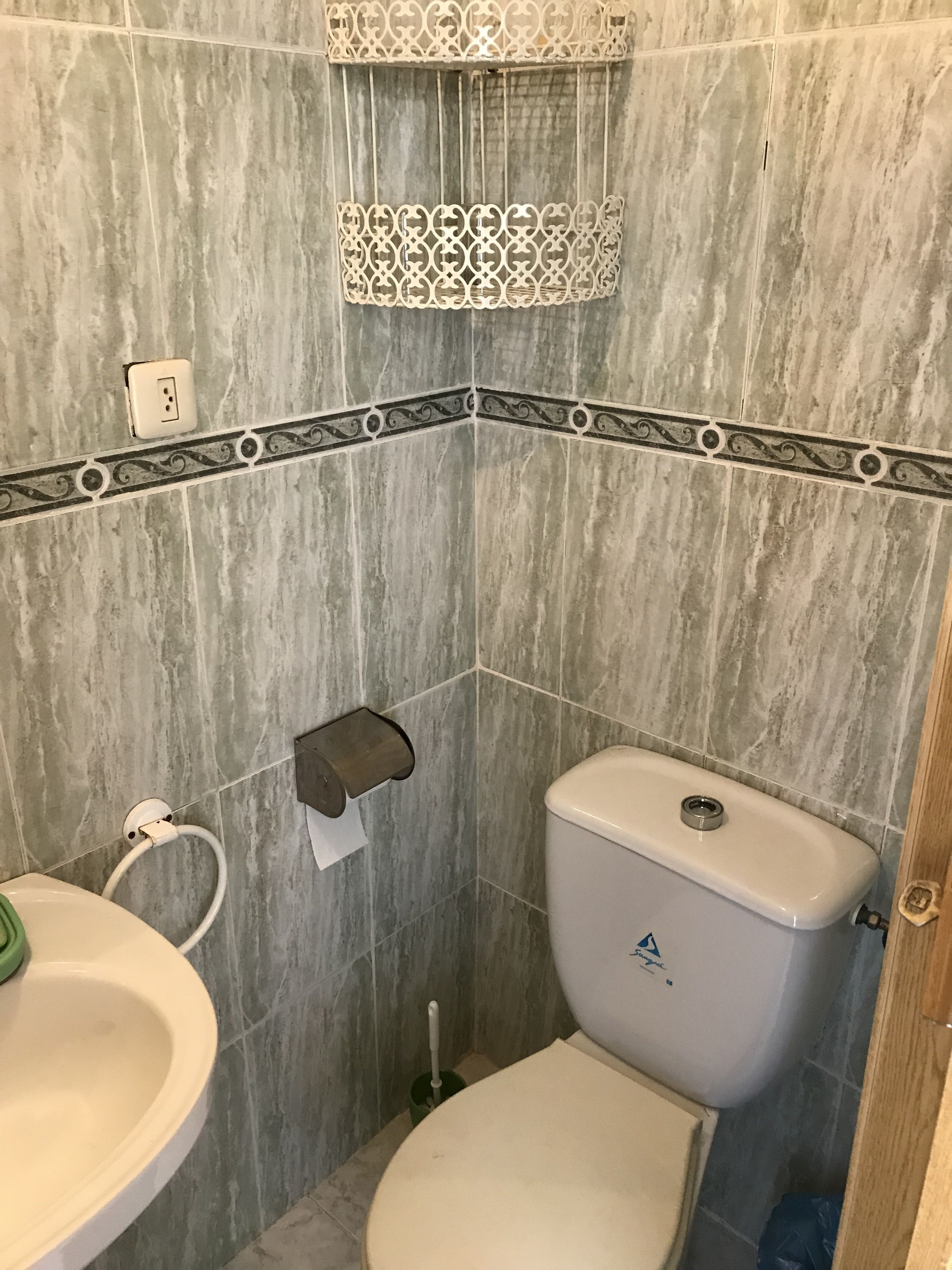 A bathroom with a toilet, sink, and shower area.