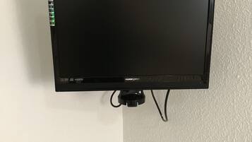 A flat-screen TV mounted on a wall with HDMI and DVI ports, and a cable connected to it.