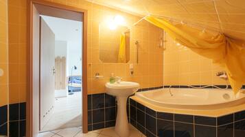 A bathroom with a bathtub, a sink, and a mirror.