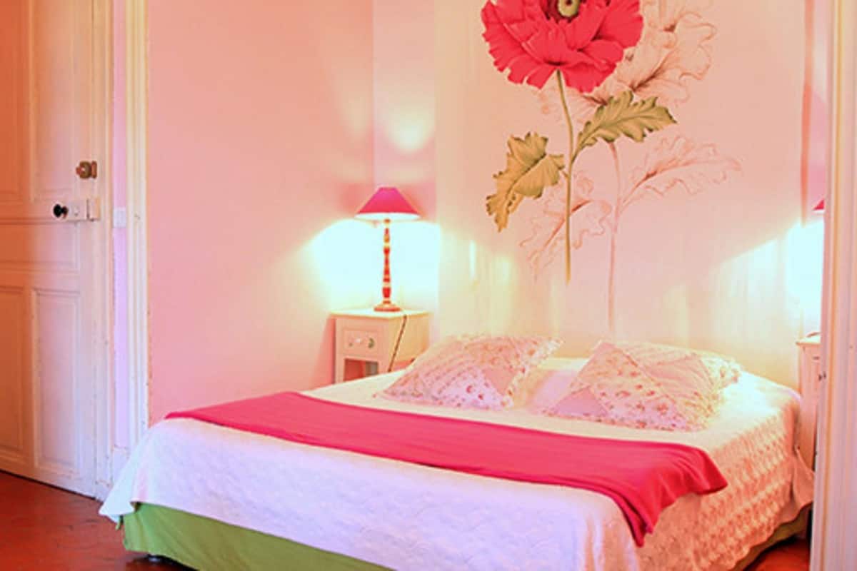 Un dormitorio con cama, cómoda, silla y puerta.