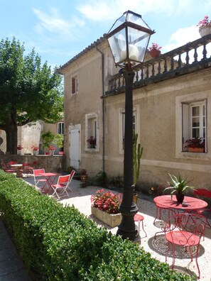 A courtyard with outdoor seating, a lamp post, and potted plants.