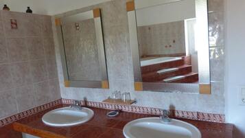 A bathroom with two sinks, mirrors, and a wooden countertop.