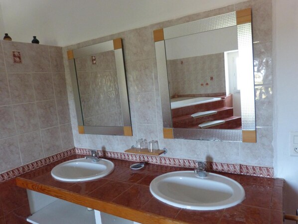 A bathroom with two sinks, mirrors, and a wooden countertop.