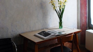 A wooden desk with a vase of yellow flowers, a book, and a chair. - B&B Camera con Vista (Fossombrone)