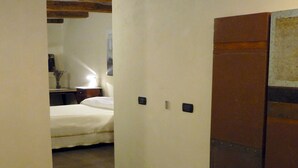 A narrow hallway with a bed and bedside table in the background. - B&B Camera con Vista (Fossombrone)