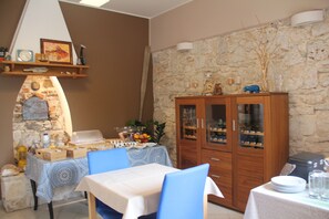 A dining area with a stone wall, wooden cabinets, and a table set for a meal. - Mobile Homes Peskera (Medulin)