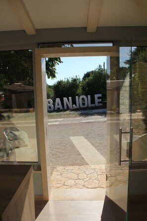 A modern building entrance with a clear view of the street and a large sign reading "BANJOLE". - Mobile Homes Peskera (Medulin)
