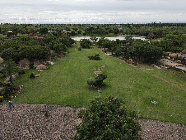 An aerial view of a park with a pond, pathways, and scattered trees. - Stephen Margolis Resort (Harare)
