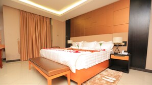A hotel room with a bed, bench, bedside table, lamp, and a rug. - Haven Hotel (Addis Ababa)
