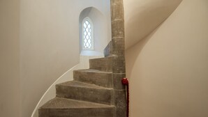 A spiral staircase with a stone handrail and a red tassel at the bottom. - East Gatehouse Lodge (Crieff)