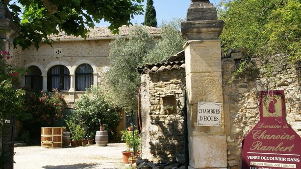 A rustic stone building with a sign reading "CHAMBRES D'HÔTES".