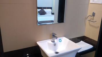 A bathroom with a white sink, a mirror, and a towel rack.